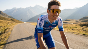 Professional road cyclist wearing premium photochromic cycling sunglasses on a bright sunny mountain road