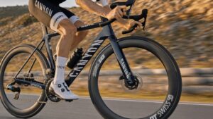 Close-up of road bike carbon wheels during high-speed ride on smooth mountain road