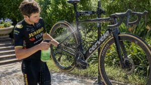 Cyclist cleaning carbon road bike with biodegradable bike wash during outdoor bicycle maintenance session