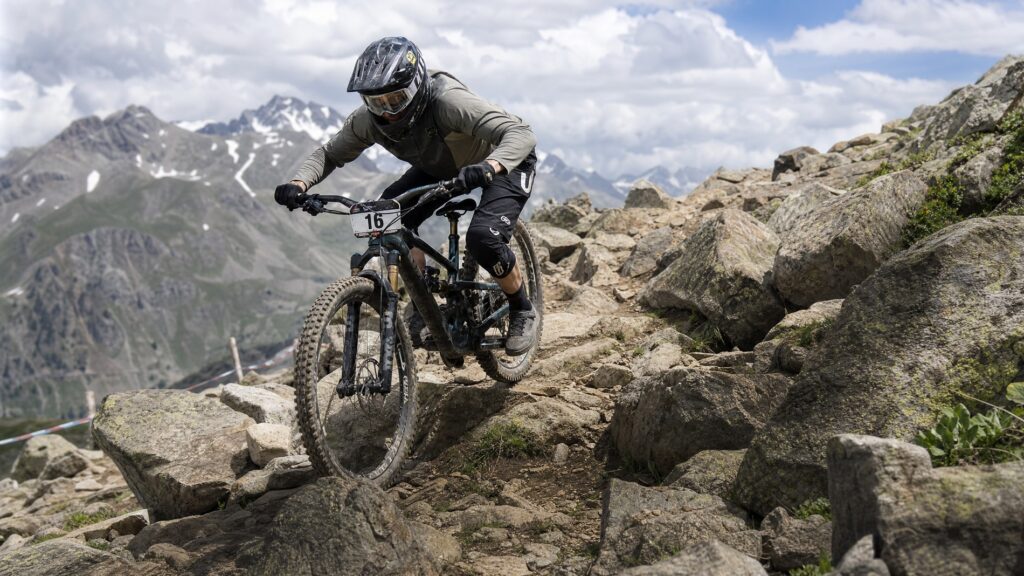 Mountain biker navigating a technical rock garden section on a challenging trail