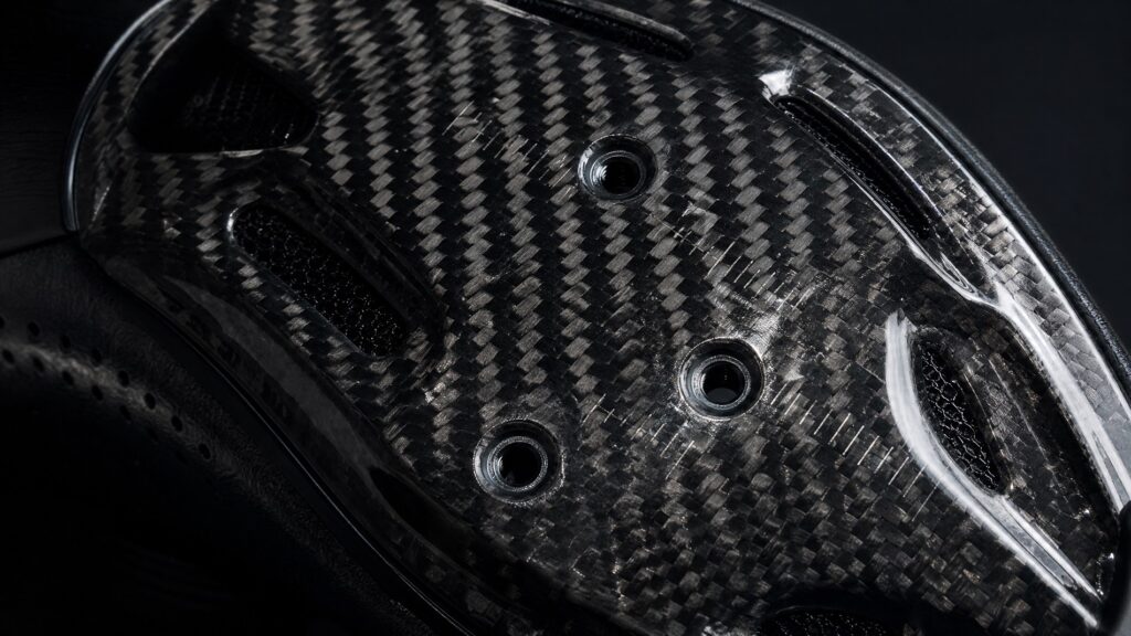 Cycling shoe carbon fiber sole showing woven texture and cleat mounting holes
