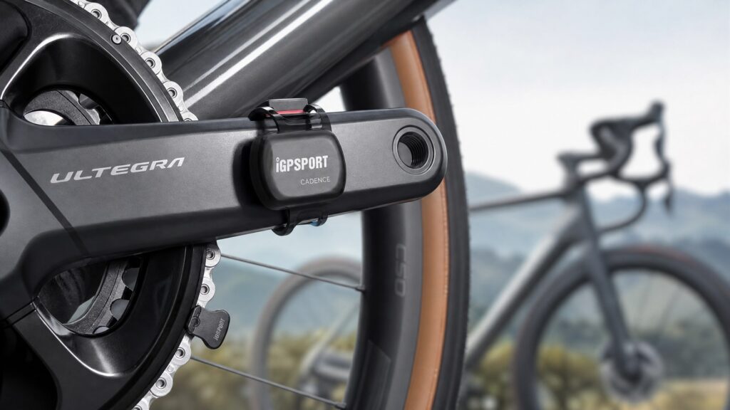 Modern cycling power meter crank arm with a wireless cadence sensor attached to a carbon road bike
