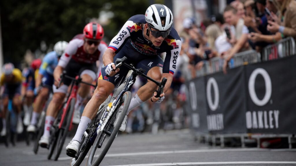 Road cyclist in full race kit sprinting at peak performance during a criterium race