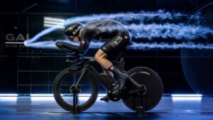 Time trial cyclist testing aerodynamic position in wind tunnel with airflow visualization